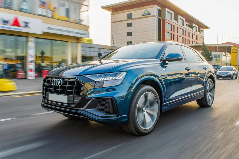 Şəhərdə hərəkətdə olan mavi Audi Q8